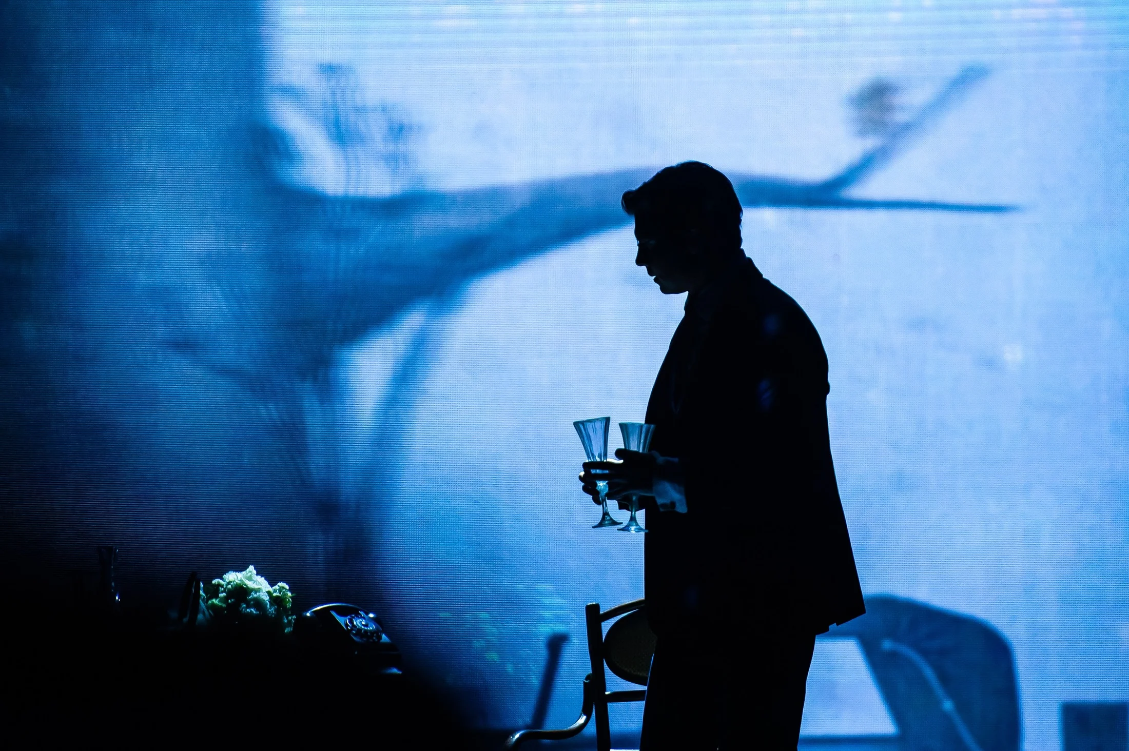 A lone performer in cold blue theatrical light