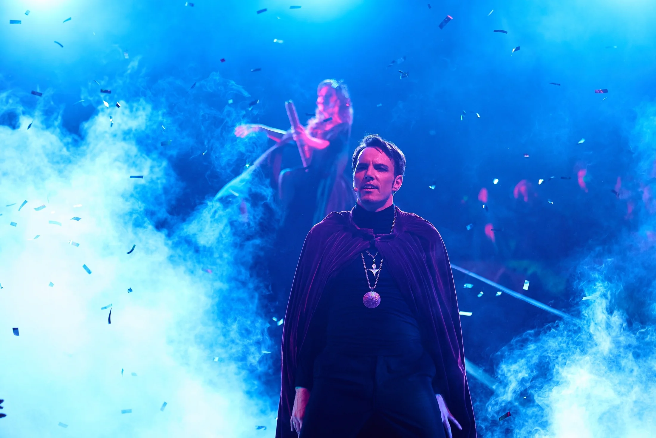 Performer crossing a beam of blue stage light