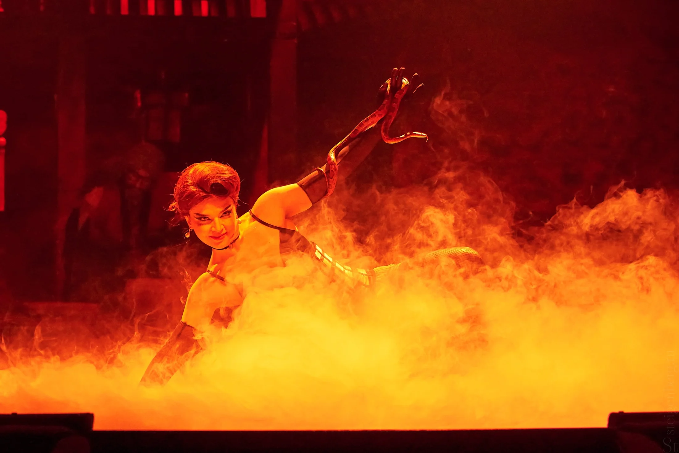 Stage figure in red-orange smoke