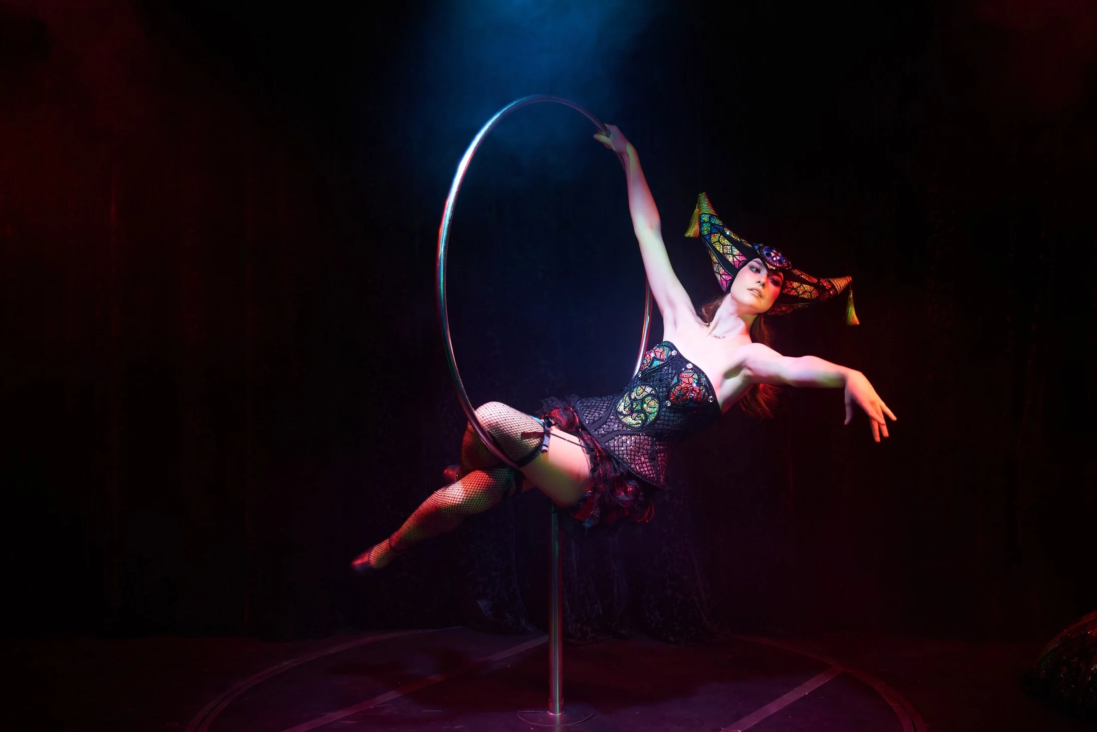 Aerial performer suspended in a dark space